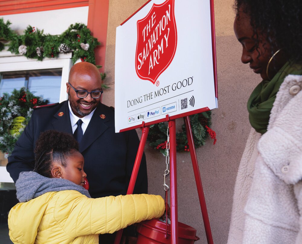 A child donates to a Salvation Army Red Kettle